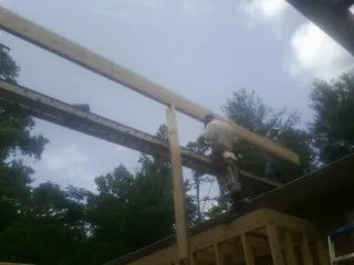 Carpenter setting a ridge beam over a new addition frame — Ice Dam Removal by Roofing Brothers in Albert Lea