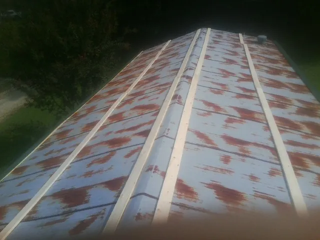 Rusted metal roof panels with new wood purlins before replacement — Storm Damage Roof Repair in Albert Lea by Roofing Brothers