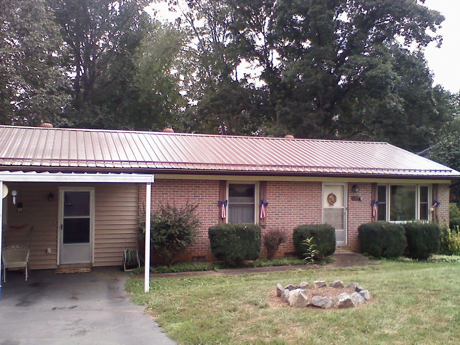 Bronze metal roof and carport on a brick ranch home — Roof Repair work by our crew in Albert Lea